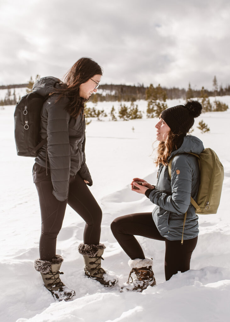 Partner proposes to her other partner in the snow with Breckenridge proposal photographer