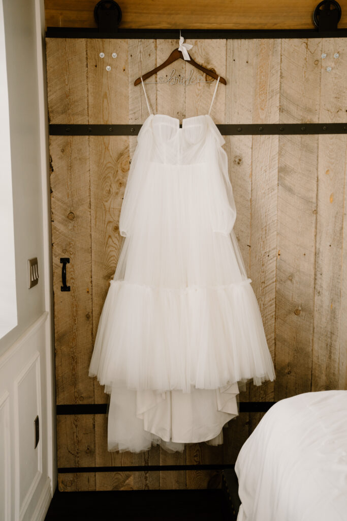 Wedding dress hanging on a wooden door