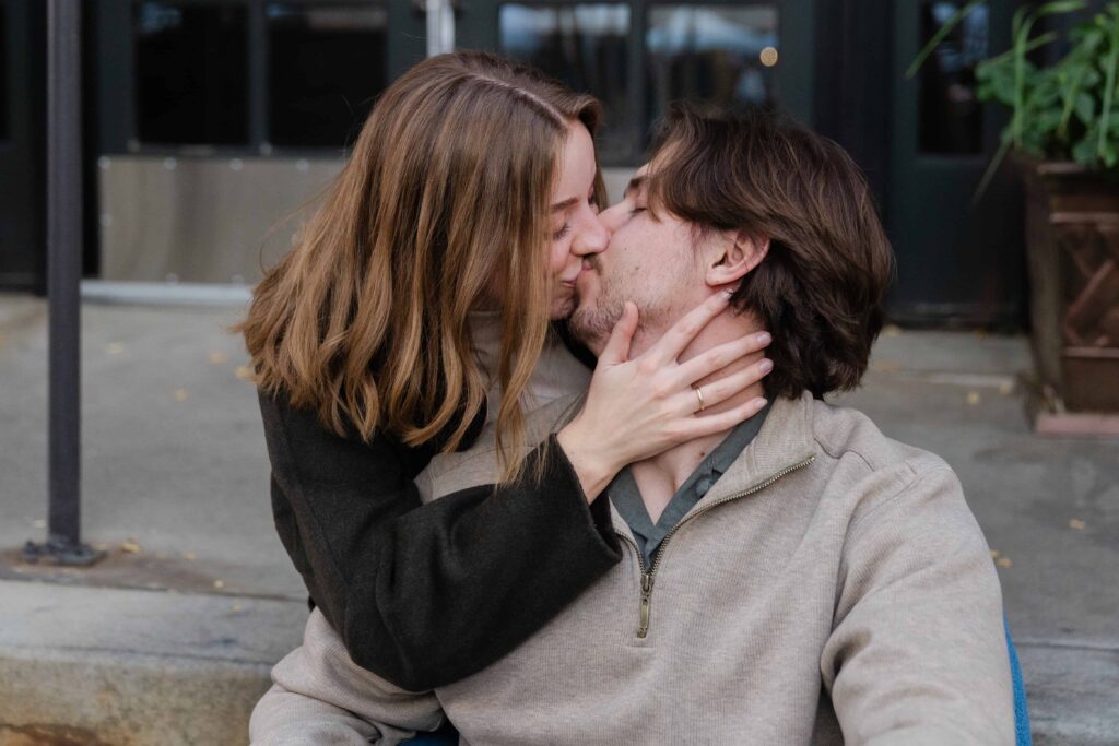 Close-up of the couple sharing a kiss while sitting outside near Union Station in downtown Denver